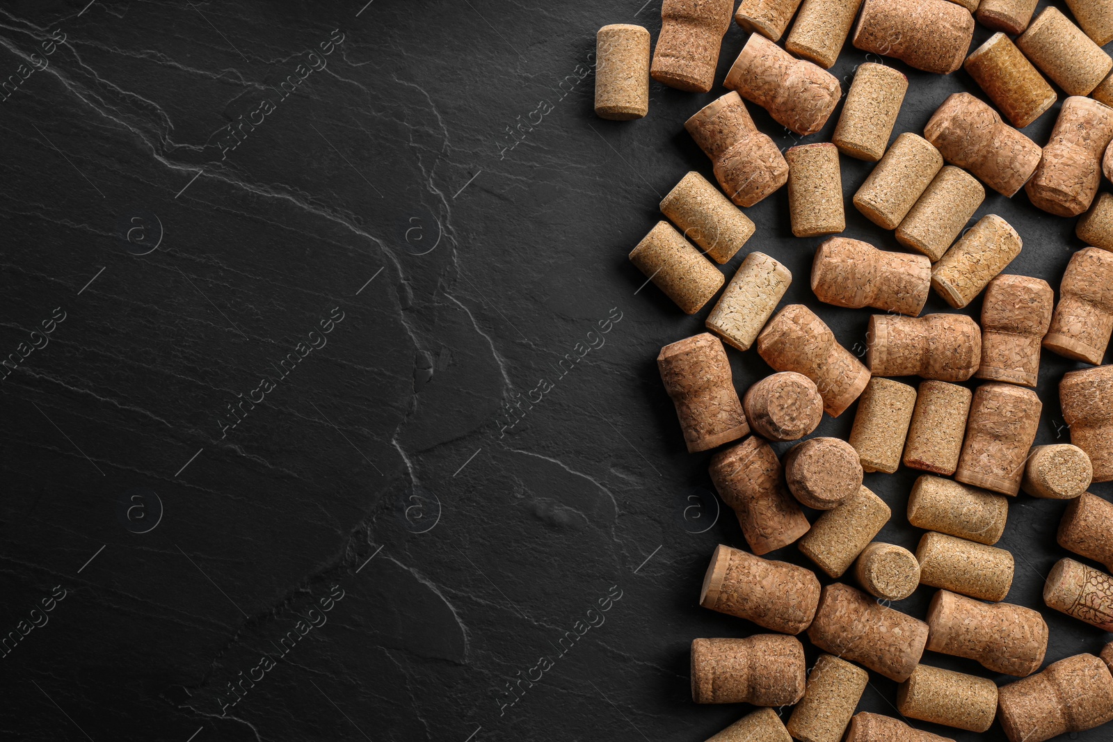 Photo of Wine bottle corks on black table, flat lay. Space for text