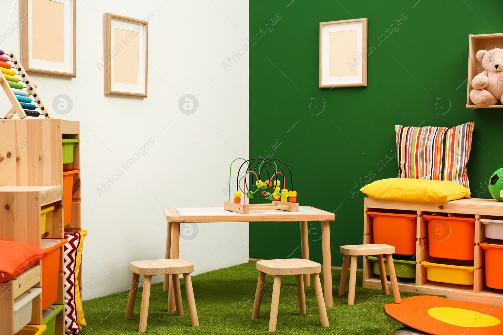 Photo of Stylish playroom interior with table and stools