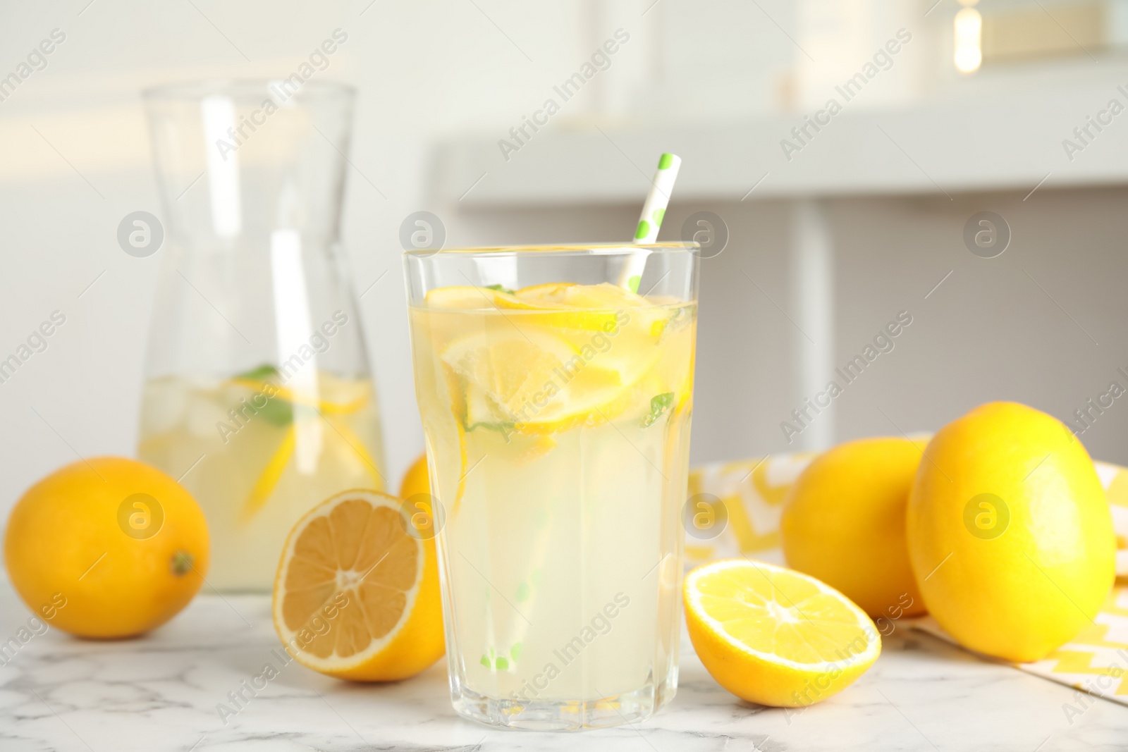 Photo of Cool freshly made lemonade and fruits on white marble table