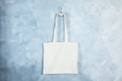 Photo of Tote bag hanging on color wall. Mock up for design