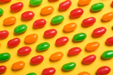 Flat lay composition with delicious jelly beans on color background