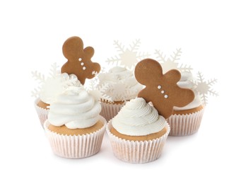 Photo of Tasty Christmas cupcakes with snowflakes and gingerbread men on white background