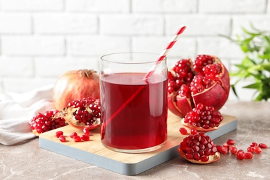 Composition with glass of fresh pomegranate juice on table