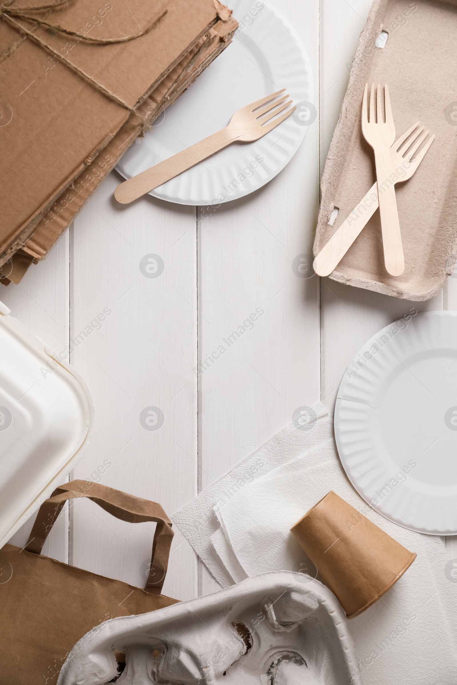 Photo of Frame of waste paper on white wooden table, flat lay. Space for text