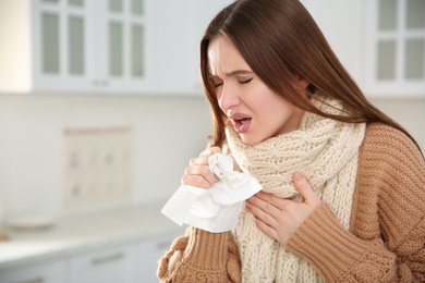 Photo of Sick young woman coughing at home. Influenza virus