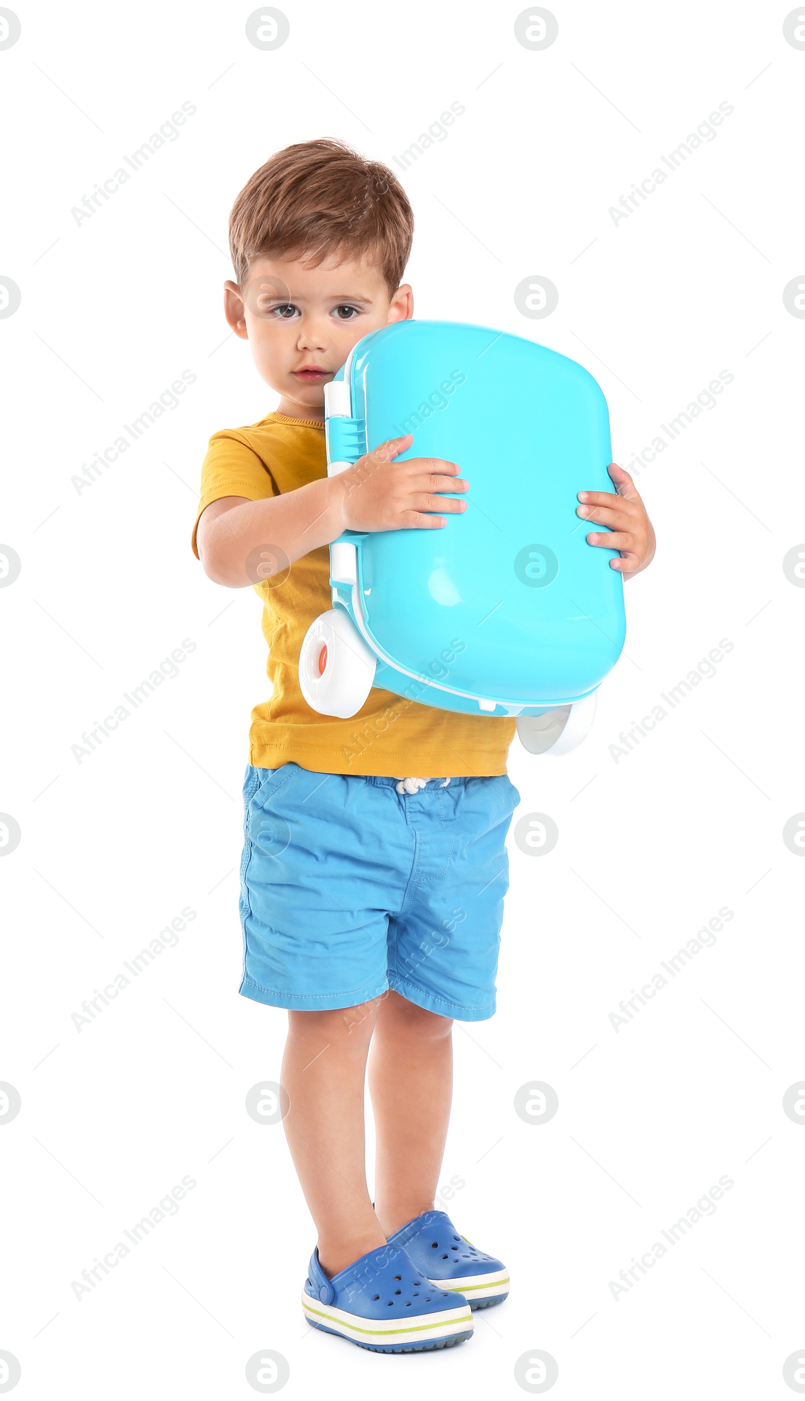 Photo of Cute little boy holding blue suitcase on white background