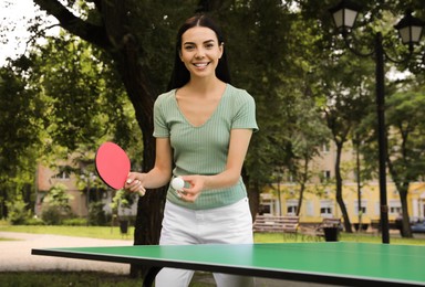 Photo of Young woman playing ping pong in park