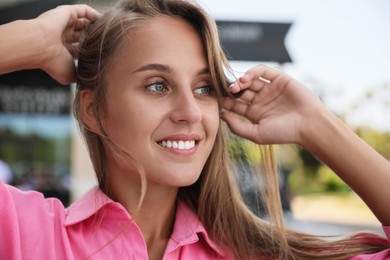 Photo of Beautiful young woman in stylish shirt on city street