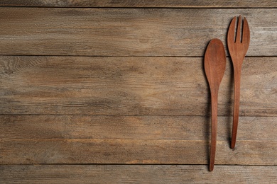 Photo of Fork and spoon on wooden table, flat lay with space for text. Cooking utensils