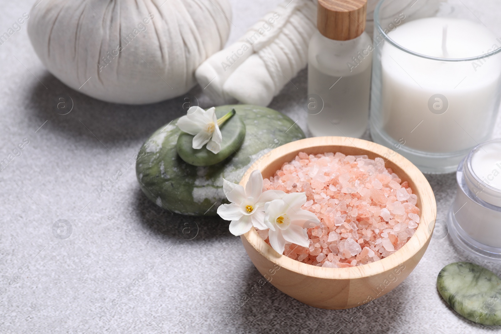 Photo of Spa composition with sea salt and flowers on light grey table