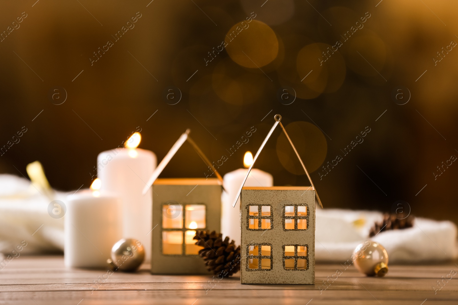 Photo of Composition with house shaped candle holder on wooden table against blurred background. Christmas decoration