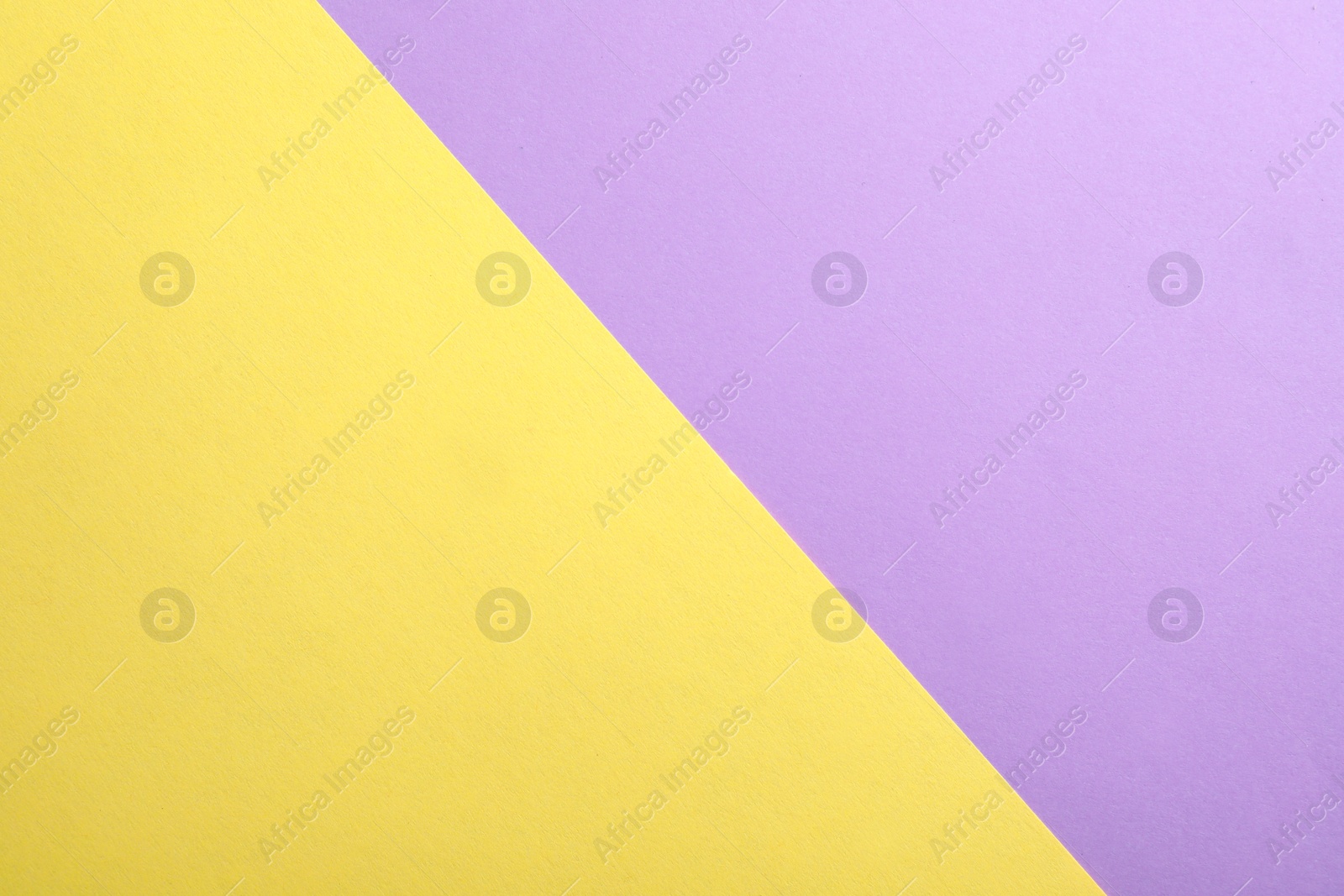 Photo of Violet and yellow paper sheets as colorful background, top view