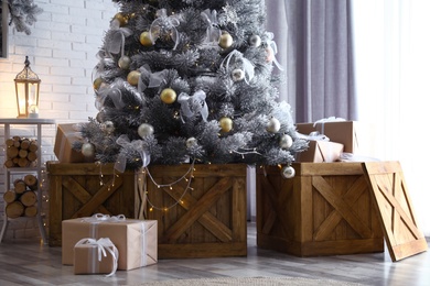 Photo of Decorated Christmas tree and gift boxes In elegant room interior