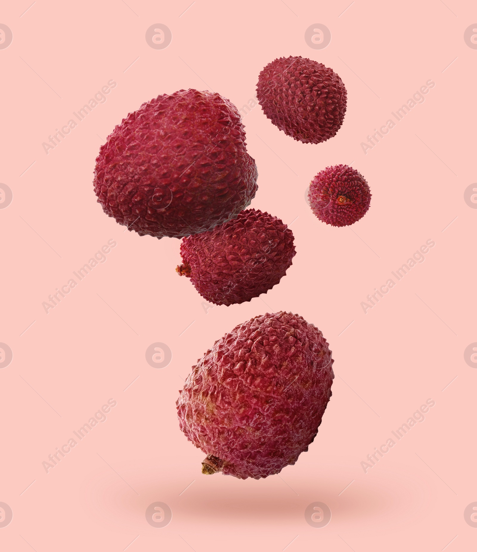 Image of Fresh lychees falling on pink beige background