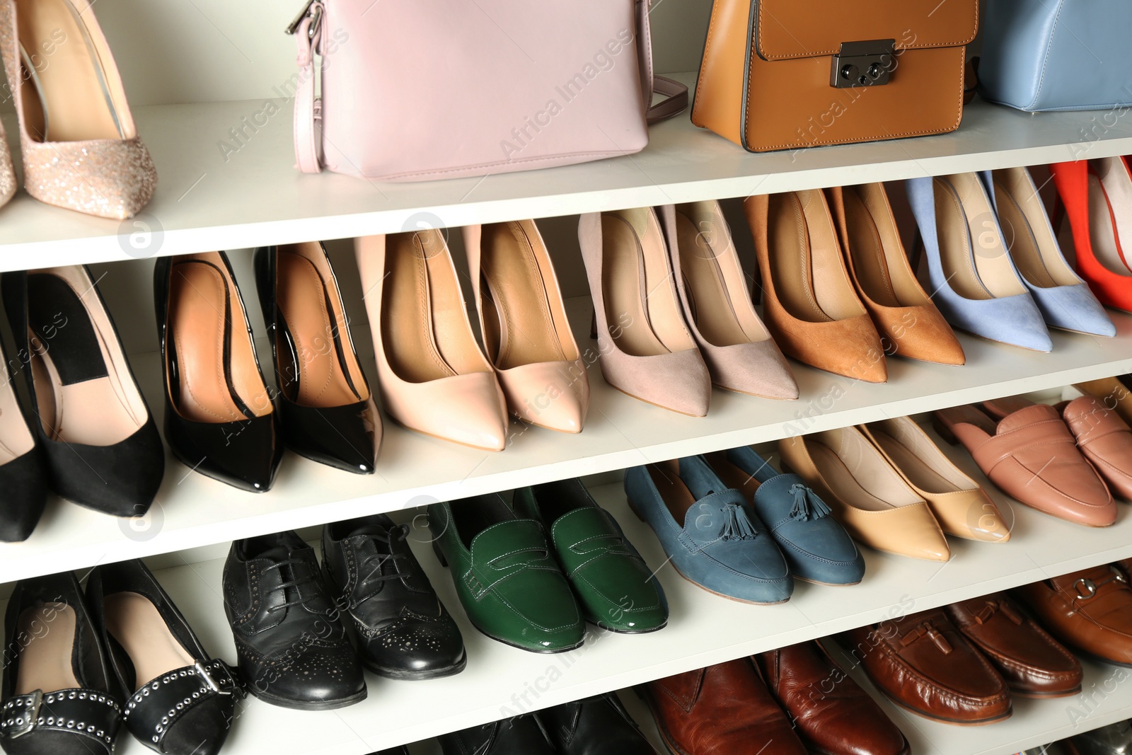 Photo of White shelving unit with different leather shoes