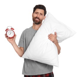 Photo of Sad overslept man with alarm clock and pillow on white background