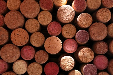 Photo of Many corks of wine bottles as background, top view