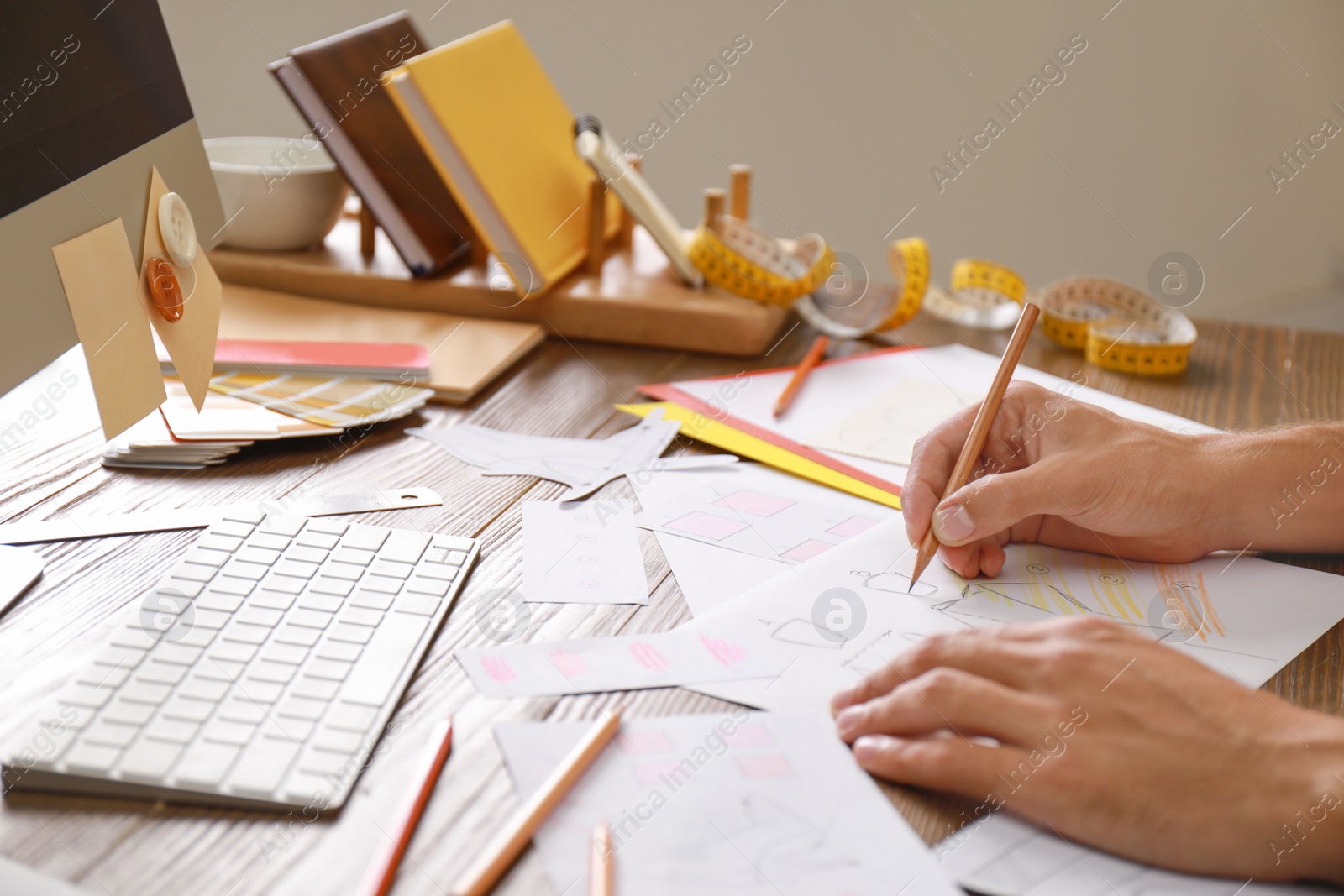 Photo of Male designer working at wooden table, closeup