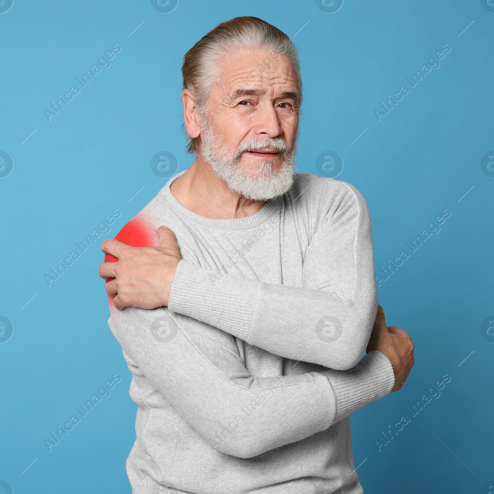 Image of Senior man suffering from rheumatism on light blue background