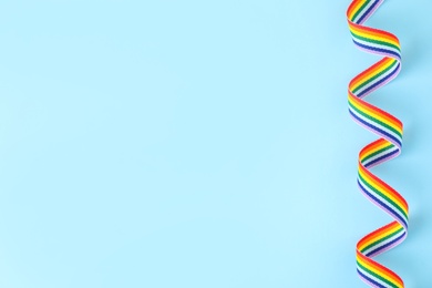 Top view of rainbow ribbon on color background, space for text. Gay symbol