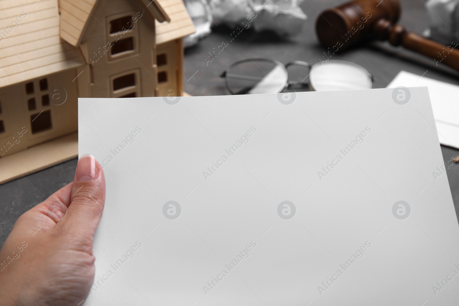 Photo of Woman holding last will and testament at grey table, closeup