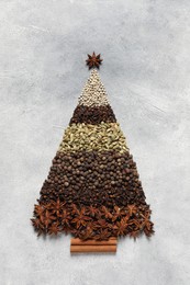 Photo of Christmas tree made of different spices on gray textured table, top view