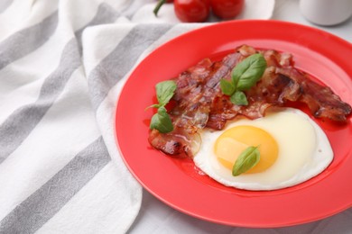 Fried egg, bacon and basil on table