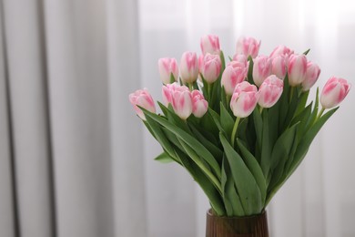 Photo of Beautiful bouquet of fresh pink tulips indoors. Space for text