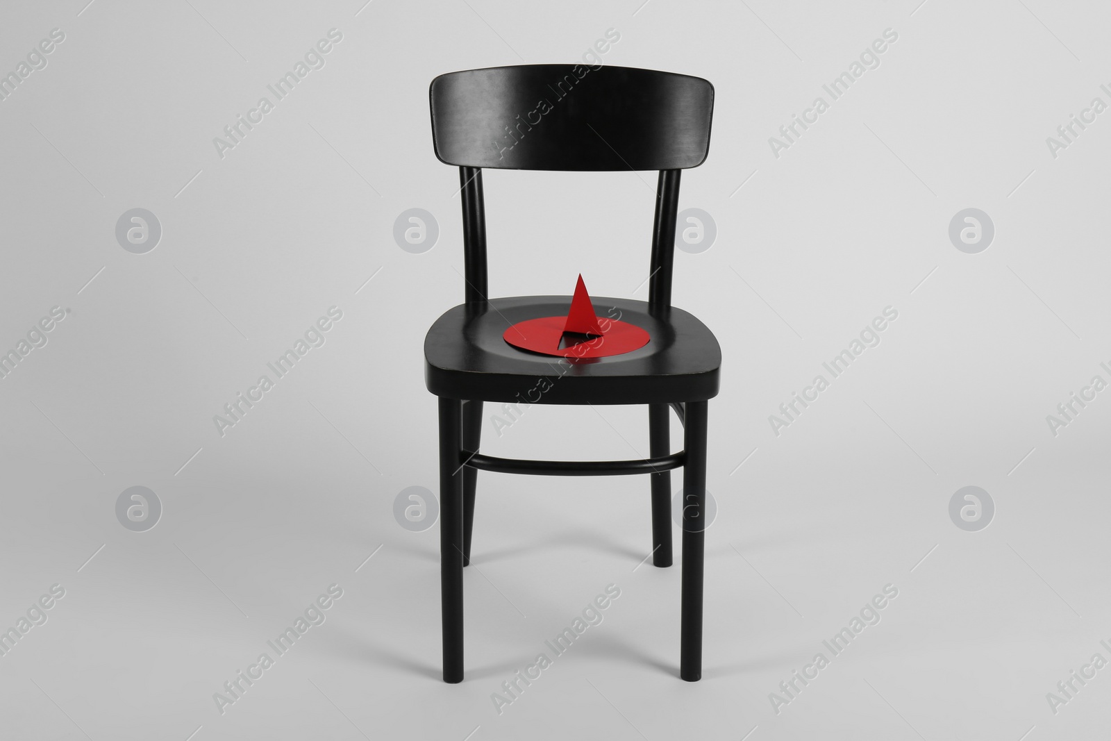Photo of Chair with large red paper pin isolated on white. Hemorrhoids concept