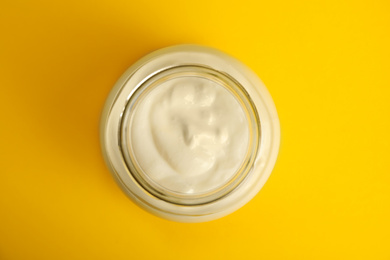 Photo of Tasty organic yogurt on yellow background, top view