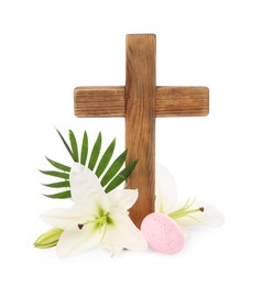 Photo of Wooden cross, painted Easter egg, lily flowers and palm leaf on white background