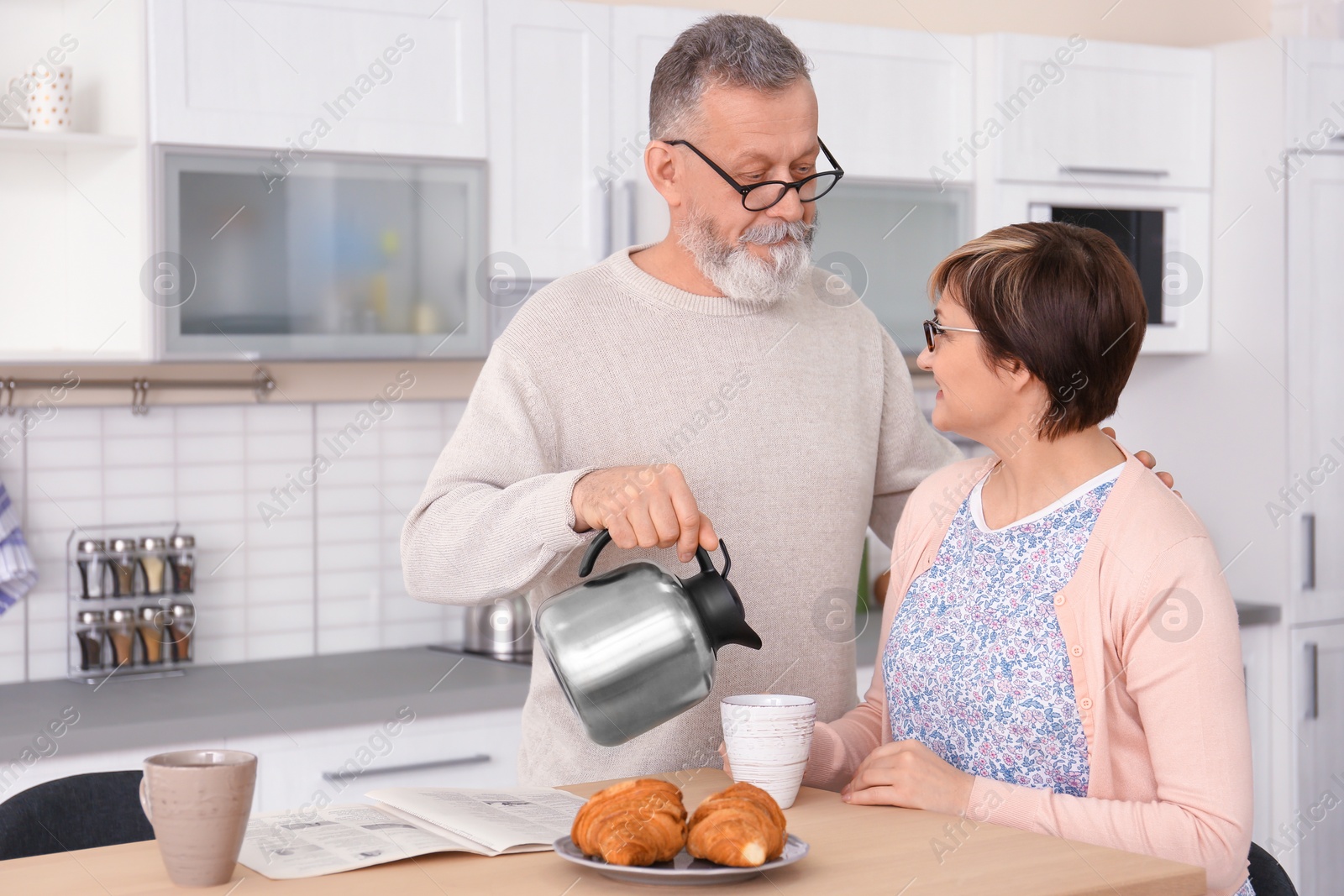 Photo of Happy senior couple having breakfast together at home