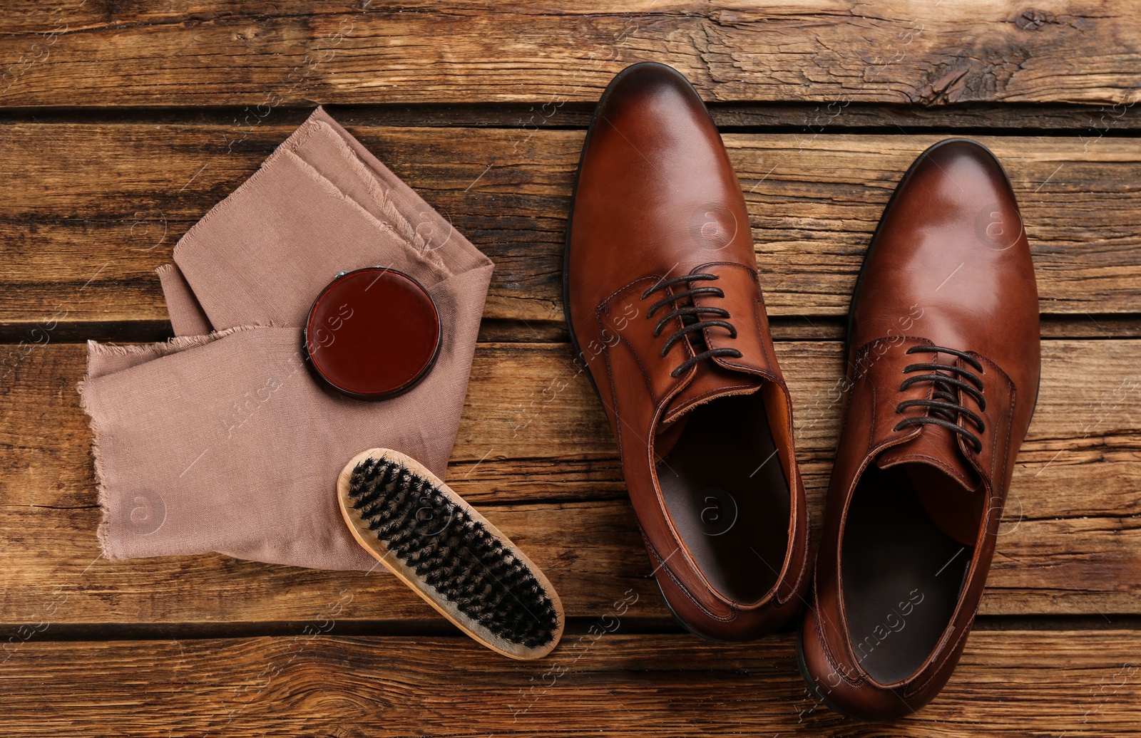 Photo of Flat lay composition with shoe care accessories and footwear on wooden background