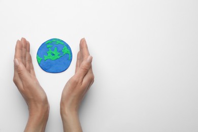 Photo of Woman and model of planet on white background, top view with space for text. Earth Day