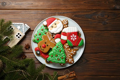 Different tasty Christmas cookies and festive decor on wooden table, flat lay. Space for text