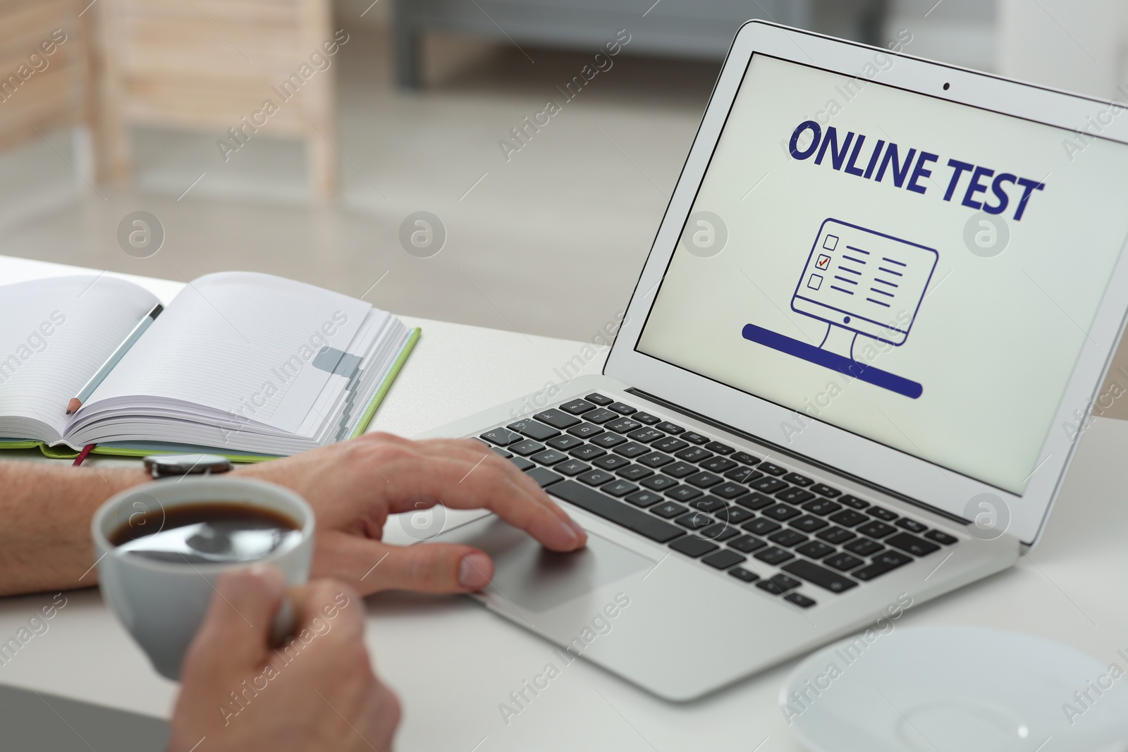 Photo of Man taking online test on laptop at desk indoors, closeup