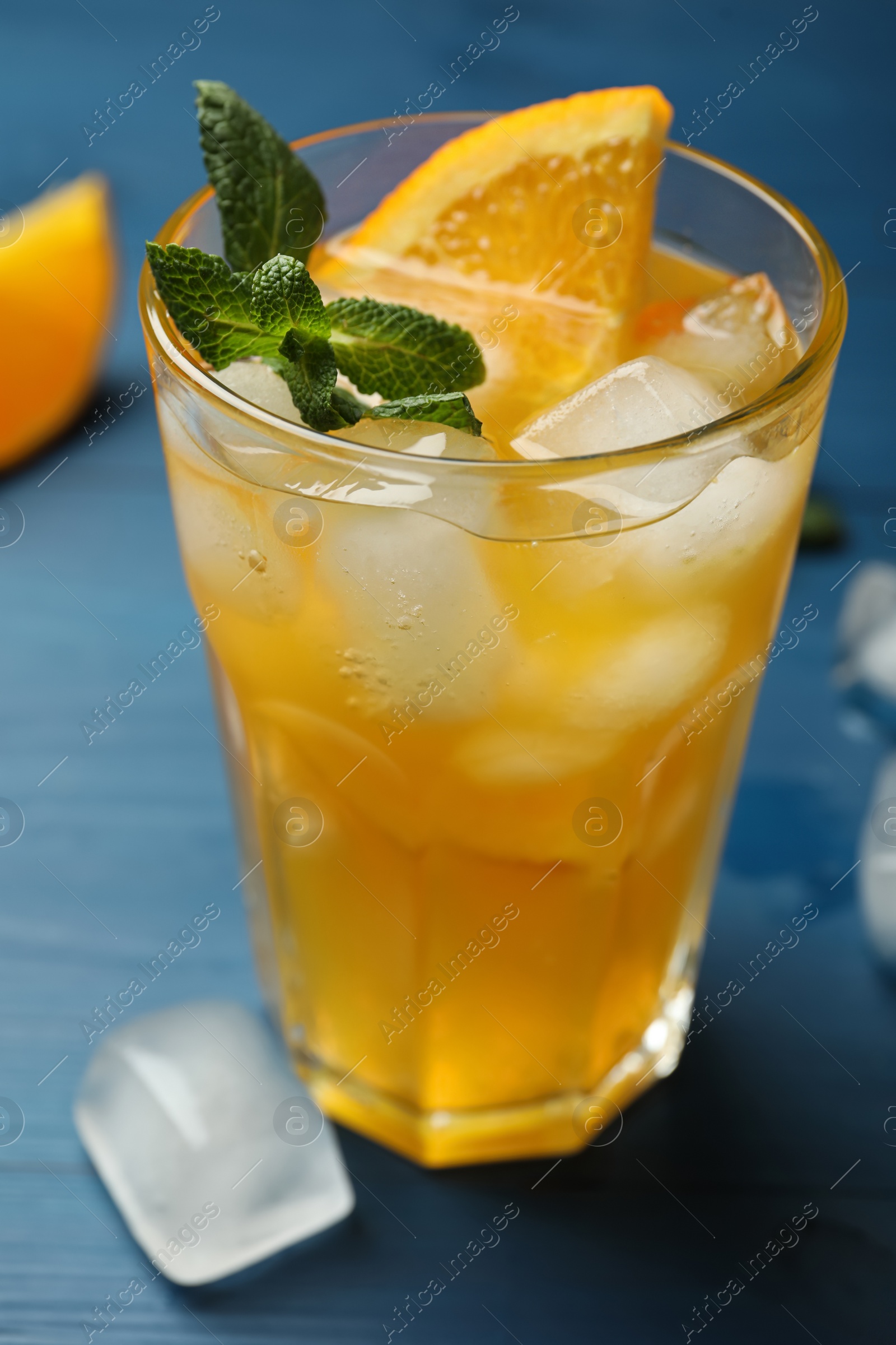 Photo of Delicious orange soda water on blue wooden table