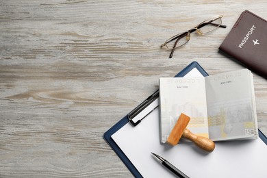 Moldova, Ceadir-Lunga - June 13, 2022: Flat lay composition with stamp, passports, pen and glasses on wooden table. Space for text