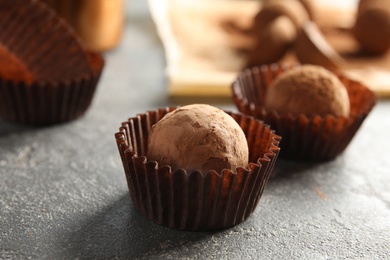 Photo of Tasty chocolate truffles on grey background, closeup