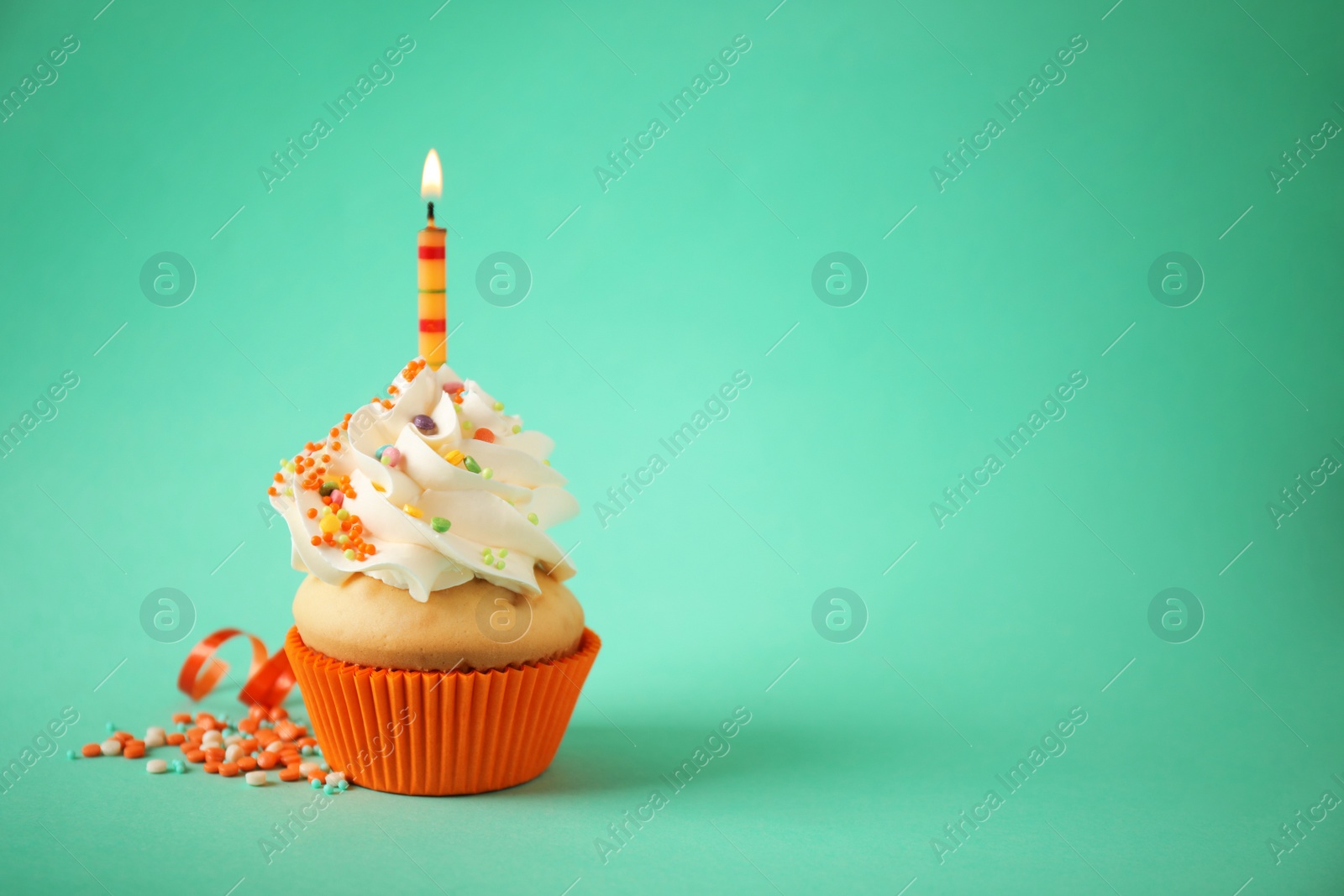 Photo of Delicious birthday cupcake with candle on light green background. Space for text