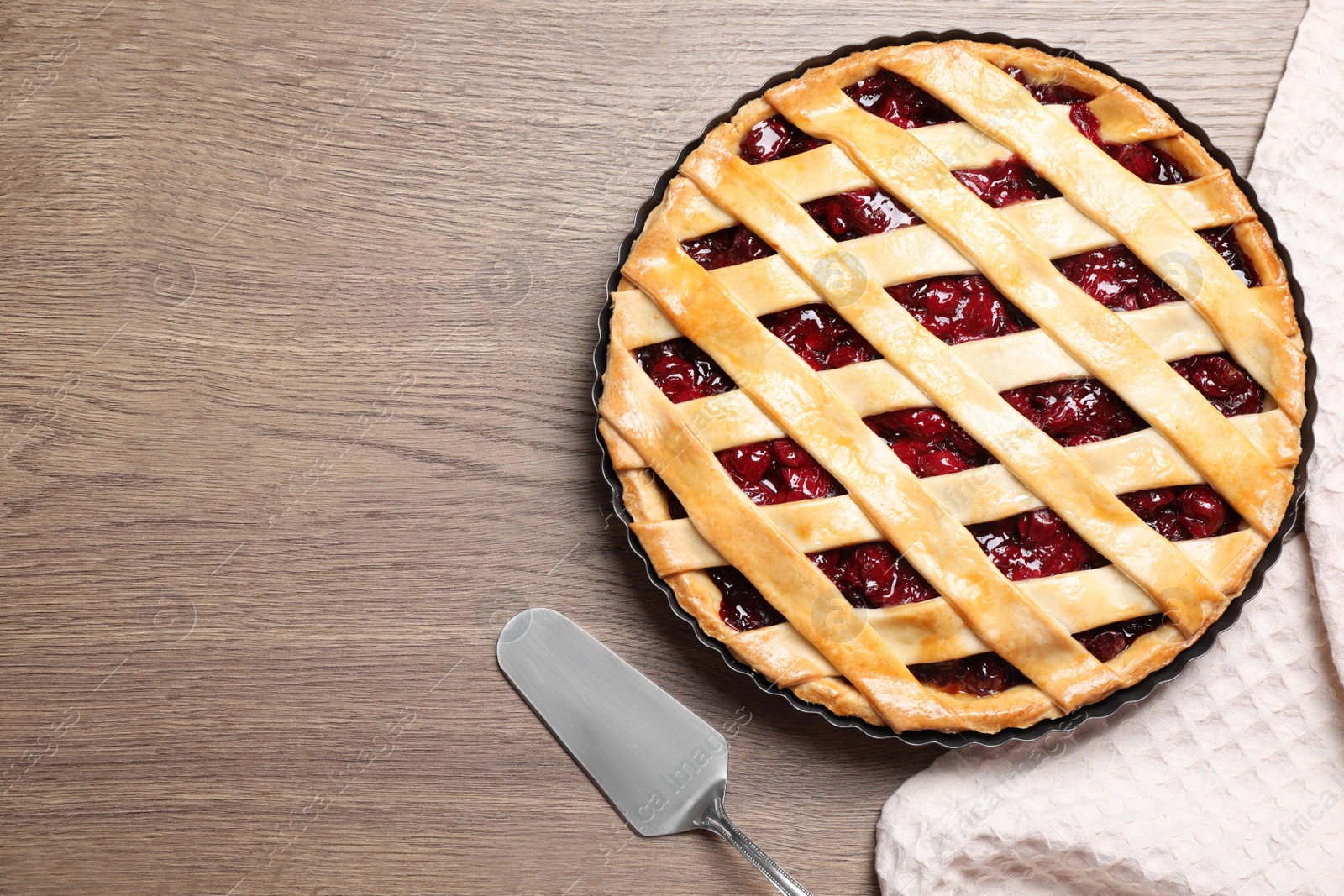 Photo of Flat lay composition with delicious fresh cherry pie on wooden table. Space for text