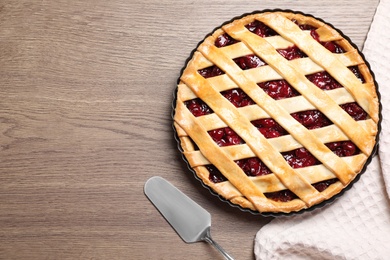 Flat lay composition with delicious fresh cherry pie on wooden table. Space for text