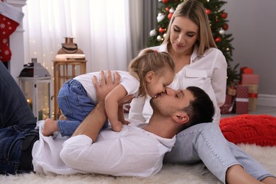 Photo of Happy family in room decorated for Christmas