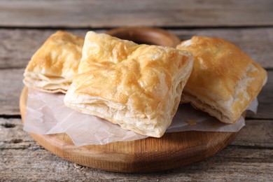 Photo of Delicious puff pastry on wooden table, closeup