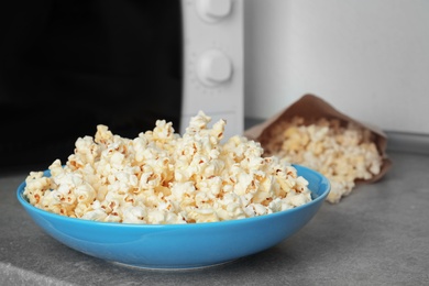 Bowl with tasty popcorn on table in kitchen