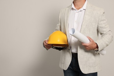 Photo of Professional engineer with hard hat and draft on white background, closeup. Space for text