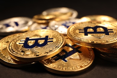 Photo of Shiny gold bitcoins on dark background, closeup view. Digital currency