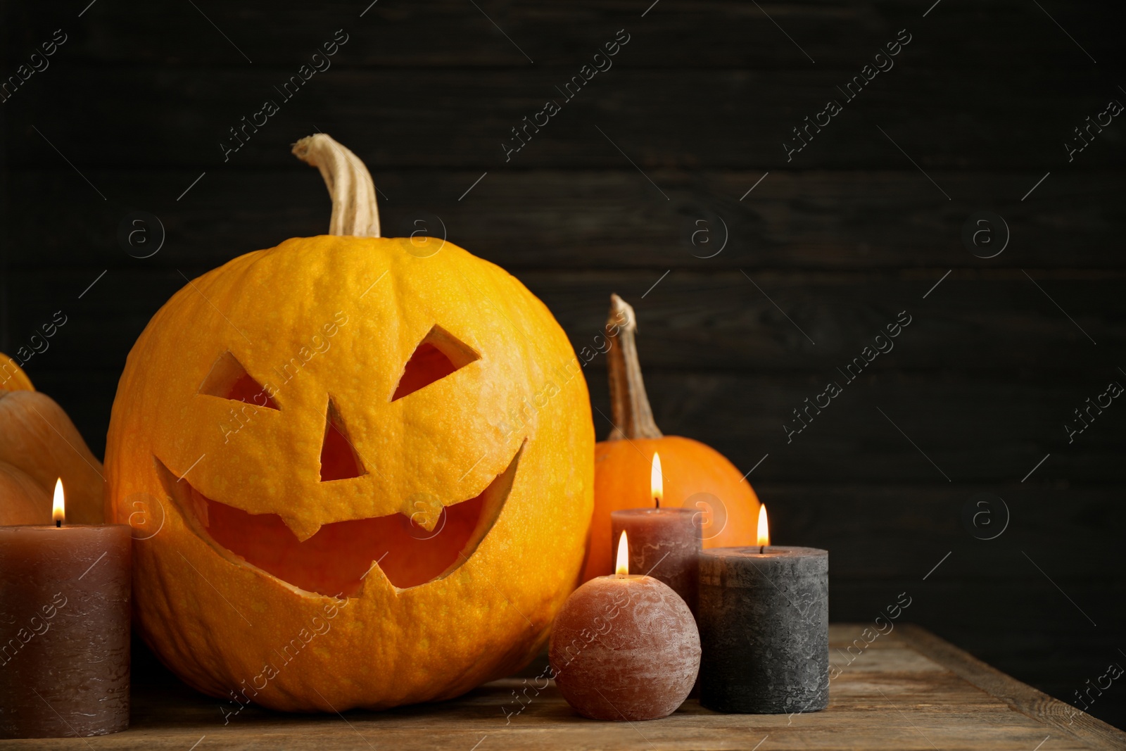 Photo of Composition with pumpkin head on dark background, space for text. Jack lantern - traditional Halloween decor