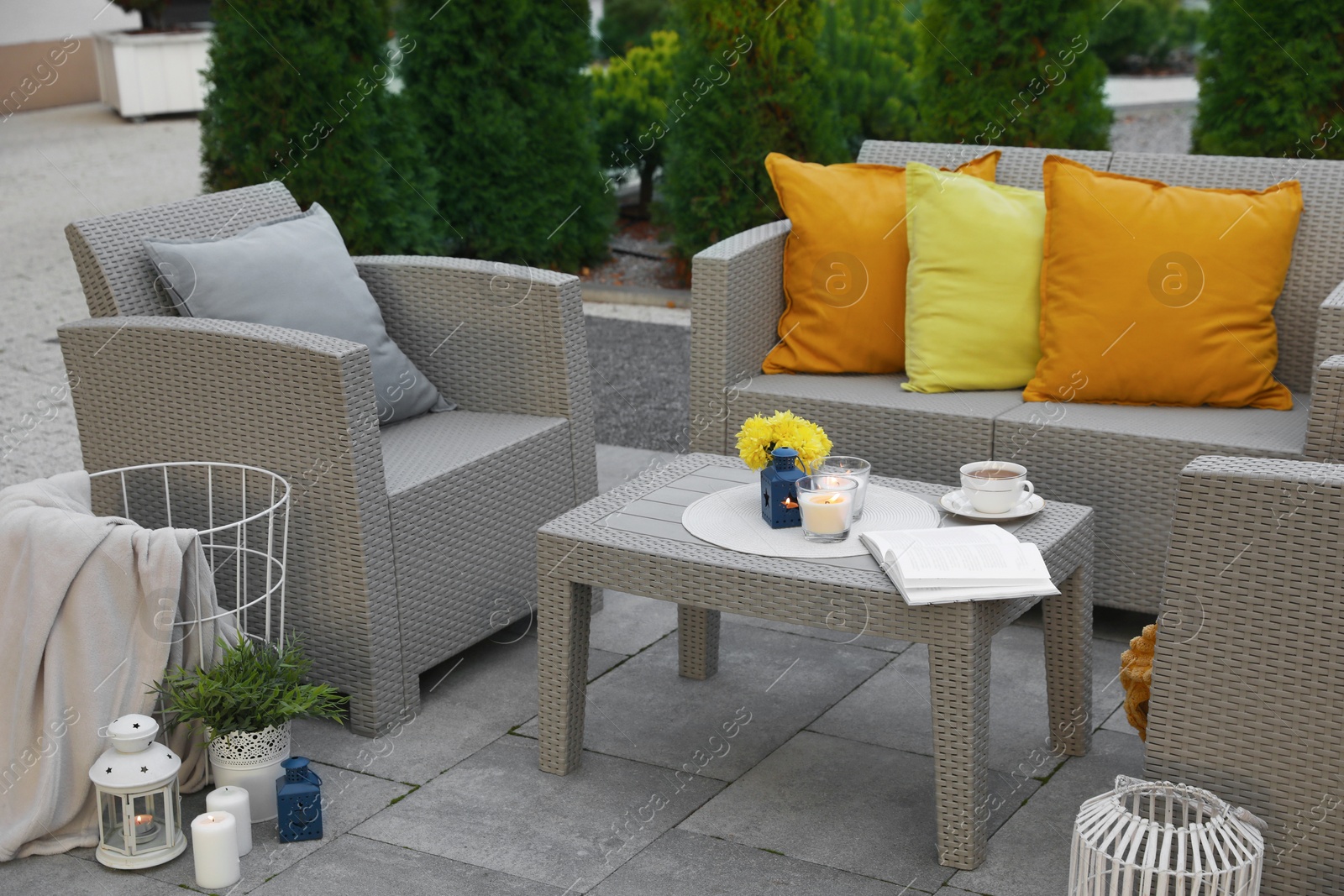 Photo of Beautiful rattan garden furniture, soft pillows and different decor elements in backyard