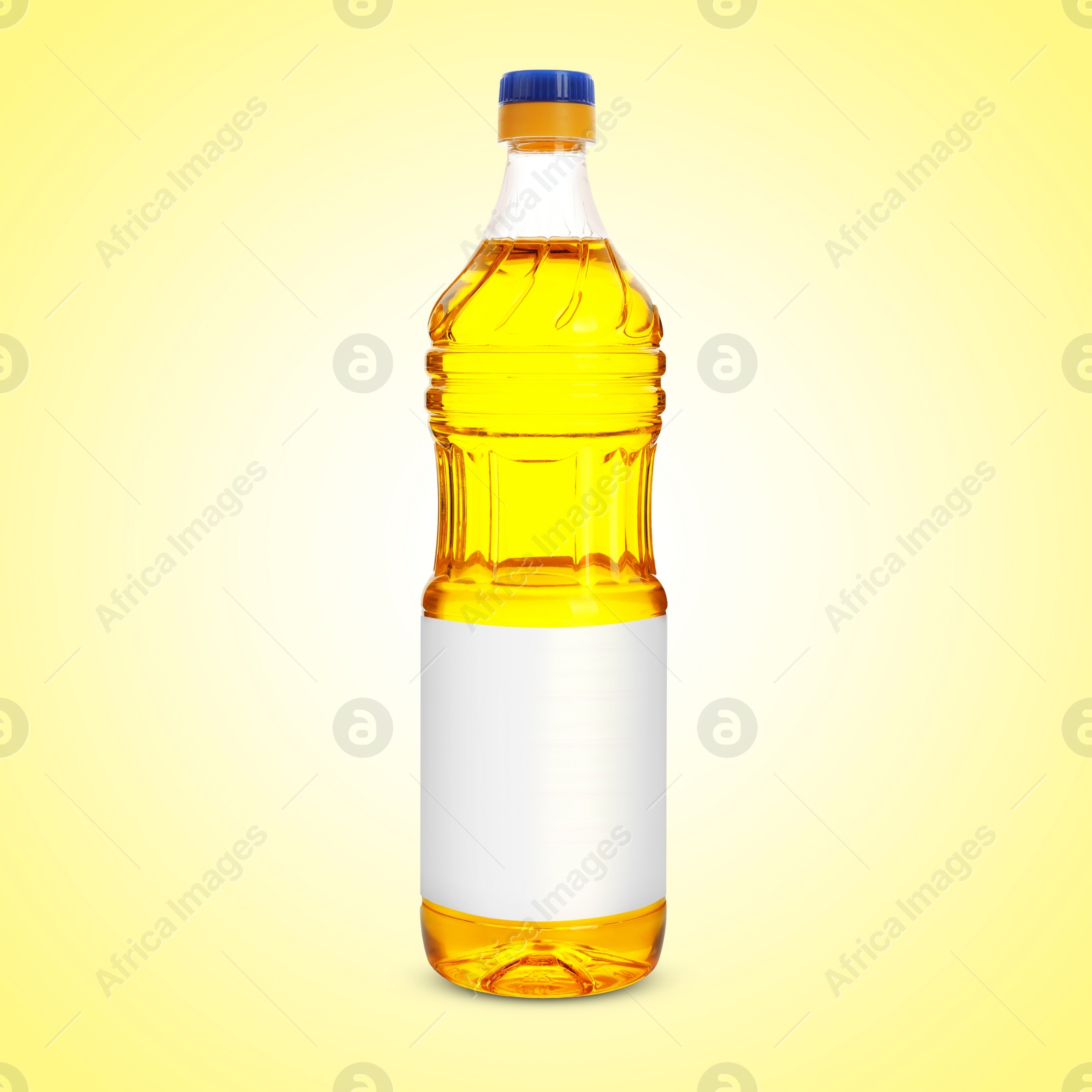 Image of Cooking oil in plastic bottle with empty label on light yellow background. Mockup for design